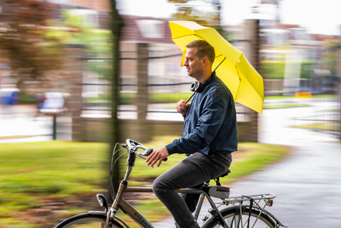 Man op fiets met paraplu
