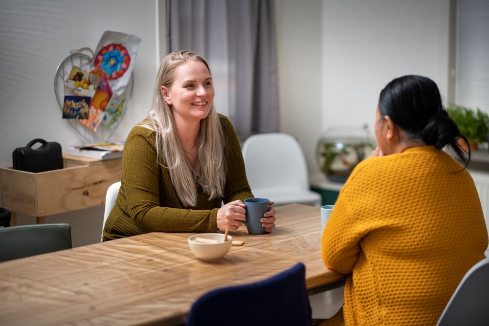 Twee vrouwen praten met elkaar aan tafel