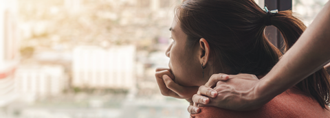 Vrouw naar buiten staren met extra hand op de schouder