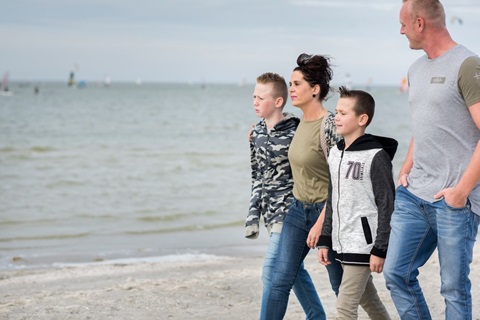 Gezin loopt op het strand