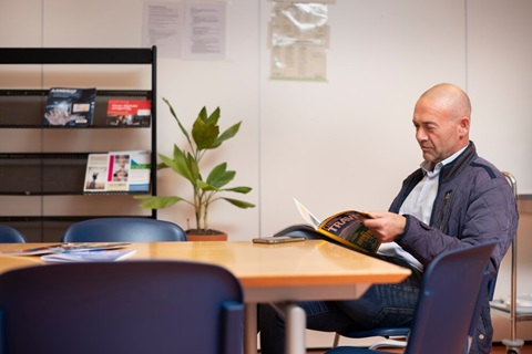 Man leest tijdschrift in wachtkamer