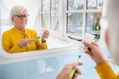 Vrouw doet tandpasta op een tandenborstel