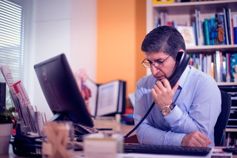 Huisarts aan de telefoon achter bureau