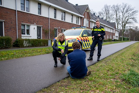 Politievrouw spreekt zittende man aan