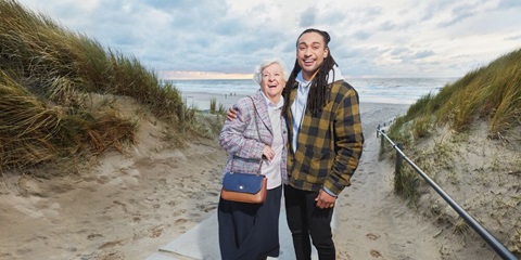 Jonge man en oudere vrouw op het strand