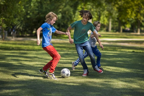 kinderen voetballen in het park