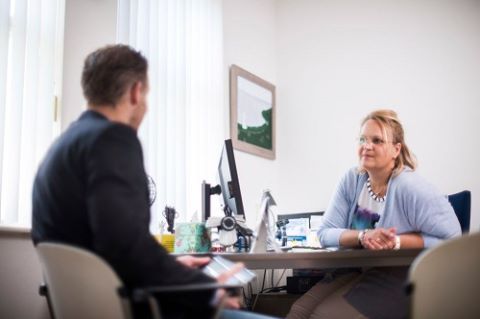 mannelijke patient bij huisarts aan tafel