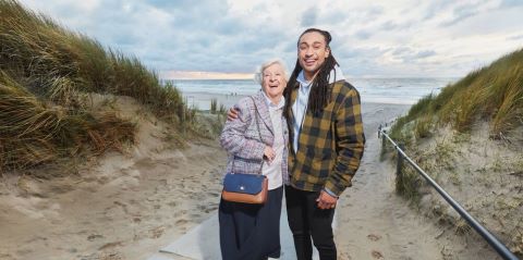 Jonge man en oudere vrouw op het strand