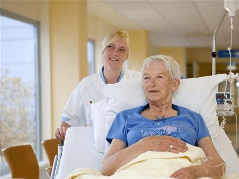 Patiënte in ziekenhuisbed met verpleegster
