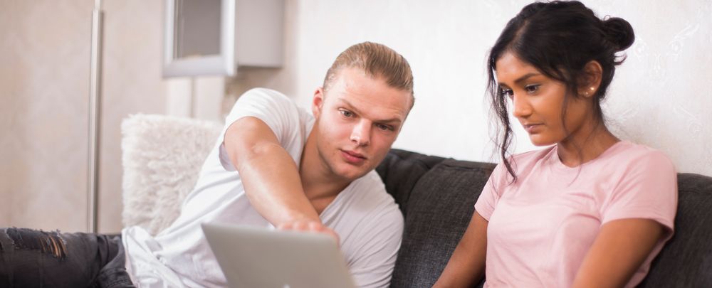 Jong stel op bank met laptop