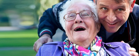 Man duwt oudere vrouw, die in een rolstoel zit