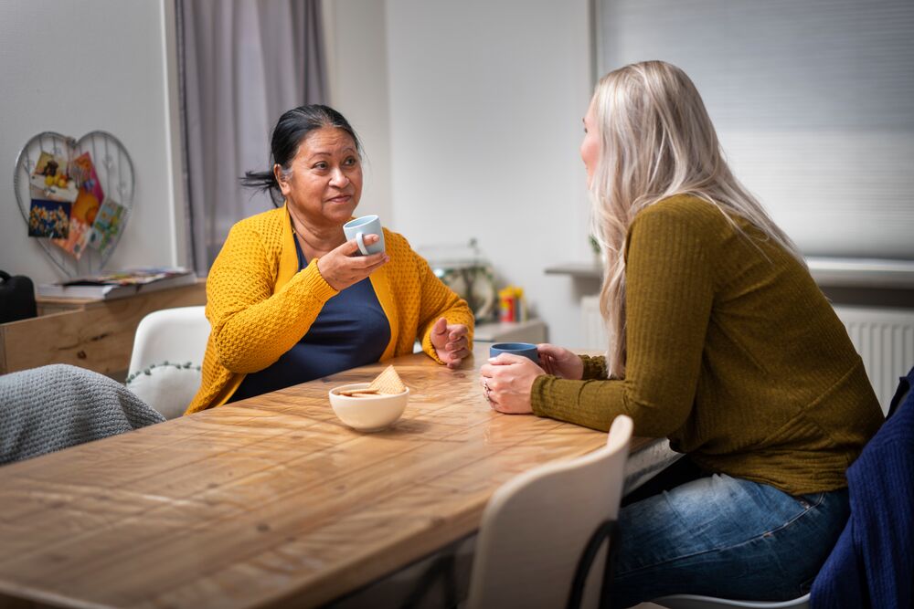 twee vrouwen aan keukentafel in gesprek