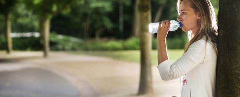 vrouw drinkt uit een plastic waterfles