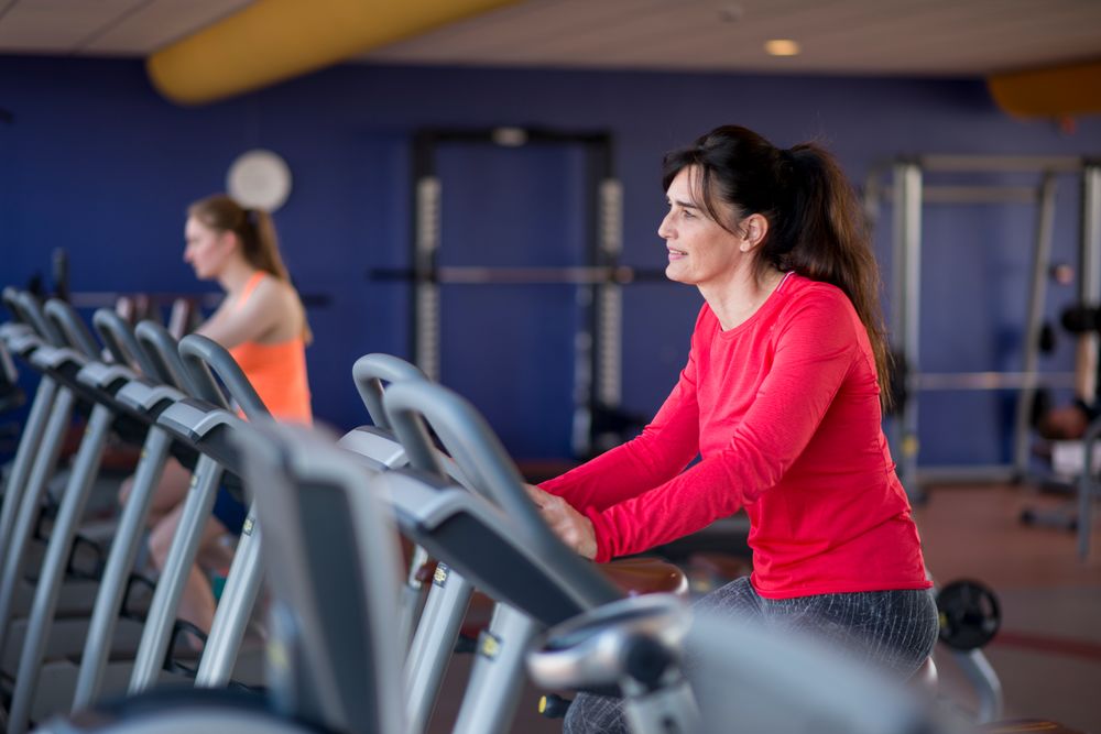 Vrouw zit op een hometrainer