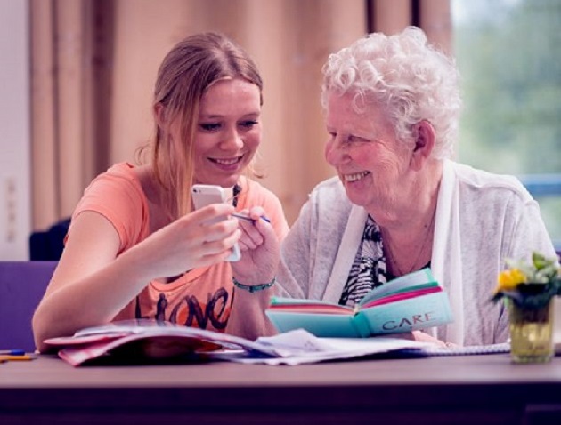Kleindochter helpt oude vrouw met mobiele telefoon
